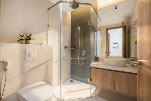 a bathroom with a shower and a toilet and a sink at Anora Home by BRIO in Danang +40 photos