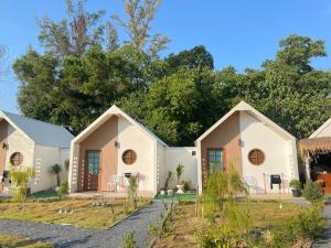a row of houses with trees in the background at Chamin Longbeach Bungalow in Ko Lanta +33 photos