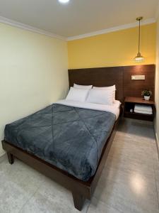 a bedroom with a large bed with a wooden headboard at KLEINN HOTEL BOGOTÁ in Bogotá