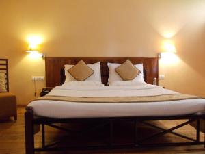 Hāflong的住宿－Landmark Hotels,Haflong，一张配有白色床单和枕头的大床