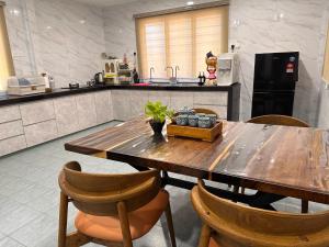 a kitchen with a wooden table and chairs at UncleLiew Cozy Home 老刘民宿 in Sekinchan