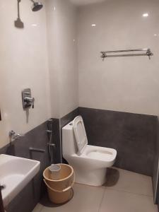 a bathroom with a white toilet and a sink at Hotel Alankar in Kanyakumari