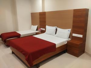 two beds in a hotel room with at Hotel Alankar in Kanyakumari