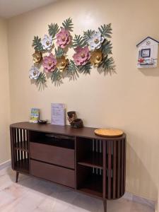 a desk with flowers on the wall at UncleLiew Cozy Home 老刘民宿 in Sekinchan