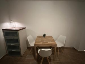 a dining room table with white chairs and a desk at Lee 42,8 in Bremerhaven