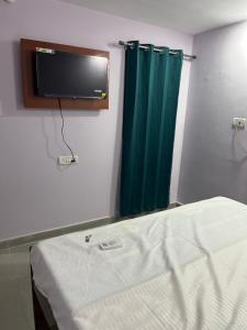 a room with a bed and a tv on the wall at Hotel Anusuiya palace in Lucknow