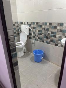 a bathroom with a toilet and a blue bucket at Hotel Anusuiya palace in Lucknow