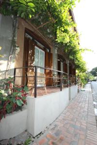 a balcony of a building with chairs and plants at Sala Prabang Hotel in Luang Prabang