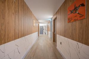 a hallway with wood paneled walls and a hallway with white tiles at Hotel PIED Suseong in Daegu