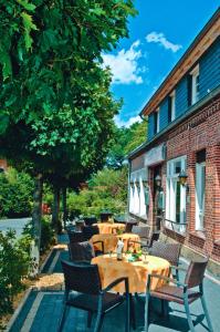 eine Terrasse mit Tischen und Stühlen neben einem Gebäude in der Unterkunft Landgasthaus Berns De Bakker in Engden
