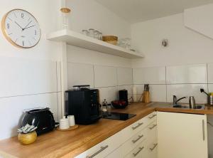 a kitchen with a clock on the wall and a counter at Deck 3 in Cuxhaven