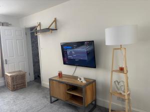 a living room with a flat screen tv on a wall at Jolly Jupiter at The Moon in Pontnewynydd +6 photos