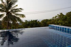 a swimming pool with a palm tree in the background at Karo Villas in Koh Tao