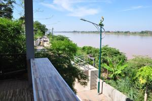 a porch with a view of a river at The Rim Riverside Guest House in Nong Khai
