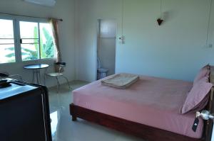 ein Schlafzimmer mit einem rosa Bett und einem Fenster in der Unterkunft The Rim Riverside Guest House in Nong Khai