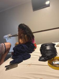 a little girl sitting on a bed with her head at Clt in Brasília