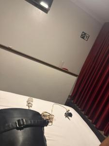 a room with a bed and a red curtain at Clt in Brasília