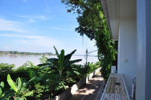a balcony with a view of the water at The Rim Riverside Guest House in Nong Khai