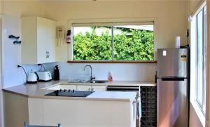 a kitchen with a stainless steel refrigerator and a window at Penneshaw Beach House in Penneshaw