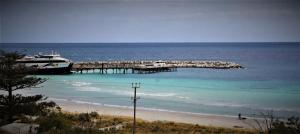 a boat is docked at a dock on the beach at Penneshaw Beach House in Penneshaw
