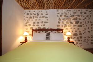 a bedroom with a green bed with two lamps at Sala Prabang Hotel in Luang Prabang