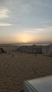 a group of people on a beach with tents at مبيت في الصحراء in Tunis +6 photos