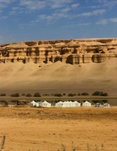 a group of tents in the desert with a mountain at مبيت في الصحراء in Tunis