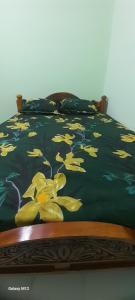 a bed with yellow flowers on a black comforter at Mahadev Residency templeview in Tiruvannāmalai