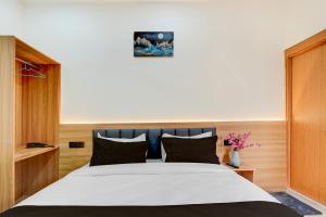 a bedroom with a large white bed with black pillows at Townhouse Roorkee Bypass in Roorkee