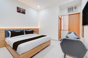 a bedroom with a large bed and a chair at Townhouse Roorkee Bypass in Roorkee +37 photos