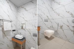 a white bathroom with a toilet and a sink at Townhouse Roorkee Bypass in Roorkee