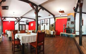 a dining room with tables and chairs and red walls at Комплекс Тракийски стан in Asenovgrad