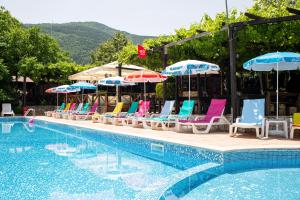 a row of chairs and umbrellas next to a swimming pool at Комплекс Тракийски стан in Asenovgrad