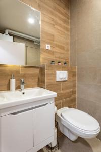 a bathroom with a white sink and a toilet at HM Apartments in Inđija +47 photos