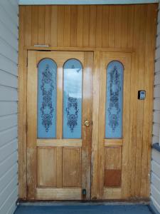 a wooden door with three windows on a house at Stirling St Surf Villa in Dunedin