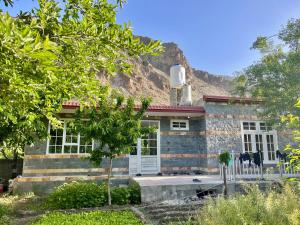 a stone house with a mountain in the background at Village Homestay in Chalt