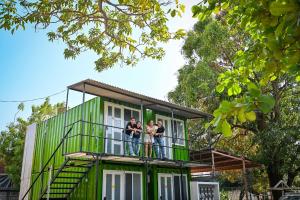 a group of people standing on the balcony of a green house at KH habitaciones in Manzanillo