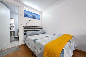 a bedroom with a bed with a yellow blanket on it at KH habitaciones in Manzanillo