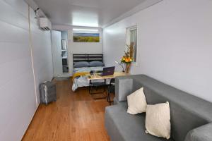 a living room with a couch and a table with a laptop at KH habitaciones in Manzanillo