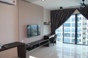 una camera d'albergo con TV e ampia finestra di Setia Inn Suites Service Residence a Setia Alam