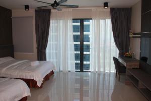 una camera con letto, scrivania e finestra di Setia Inn Suites Service Residence a Setia Alam