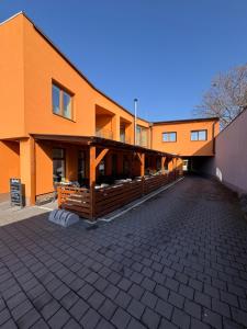 an orange building with a patio in front of it at Hotel U Kostela in Modřice
