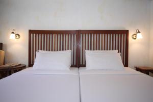 two beds with white pillows in a bedroom at Sala Prabang Hotel in Luang Prabang