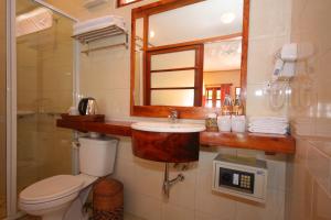 a bathroom with a toilet and a sink and a mirror at Sala Prabang Hotel in Luang Prabang