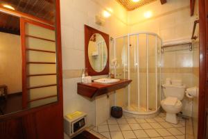 a bathroom with a shower and a toilet and a sink at Sala Prabang Hotel in Luang Prabang