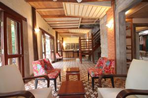 a hallway with chairs and tables in a building at Sala Prabang Hotel in Luang Prabang