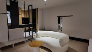 a living room with a white chair and a table at Urban Inn, Alor Setar in Alor Setar