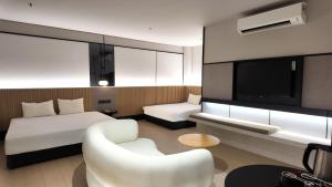 a hotel room with a bed and a couch and a tv at Urban Inn, Alor Setar in Alor Setar