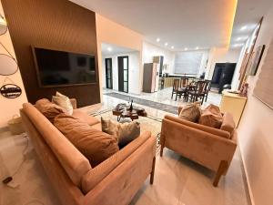 a living room with two couches and a tv at Samash villas 2 in Lusaka