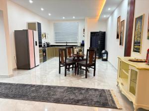 a kitchen with a table and chairs and a refrigerator at Samash villas 2 in Lusaka